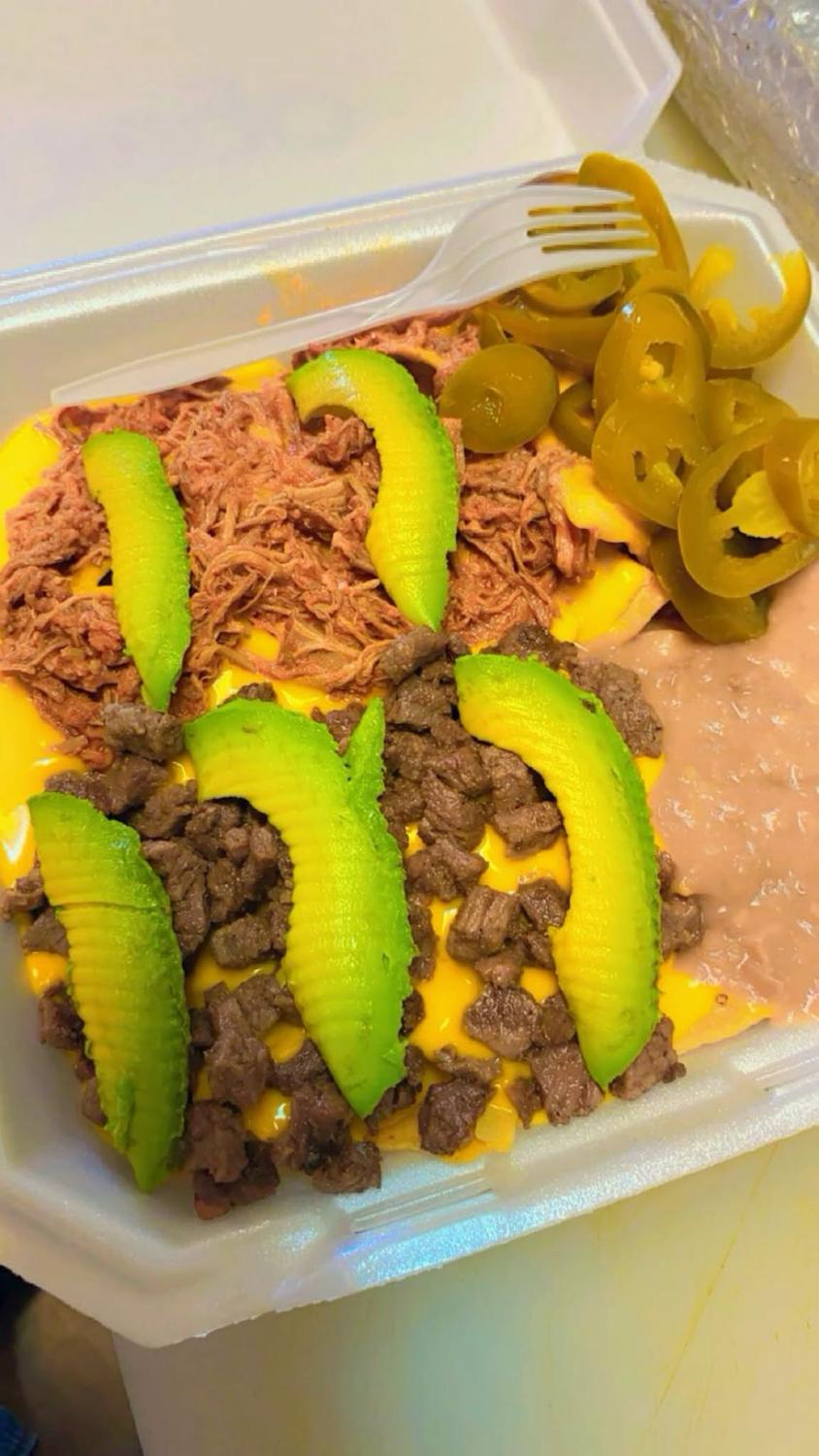 Papa al horno loaded with shredded chicken, diced beef, melted cheese, refried beans, avocado and jalapeños